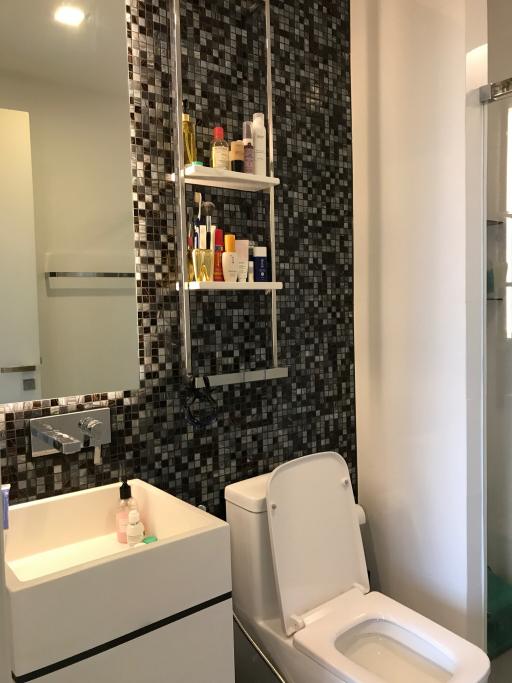 Modern bathroom with wall-mounted shelves and mosaic tiles