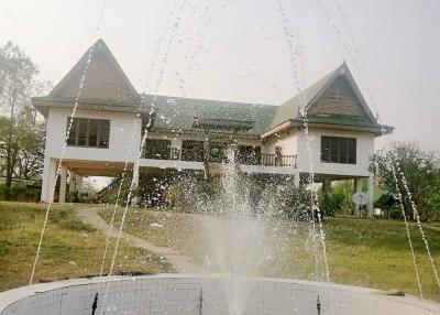 White two-story house with fountain in front