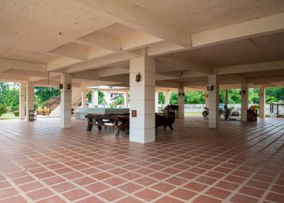 Spacious open communal area with tiled flooring and multiple columns