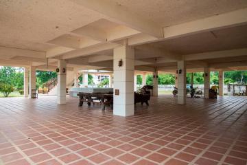 Spacious open communal area with tiled flooring and multiple columns