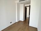 Empty bedroom with hardwood floors and natural light