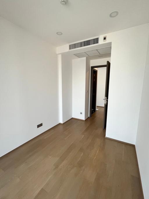 Empty bedroom with hardwood floors and natural light