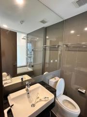 Modern bathroom interior with glass shower, sink and toilet