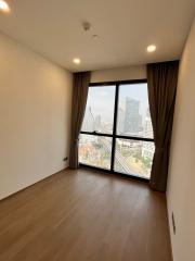 Empty bedroom with large window and city view