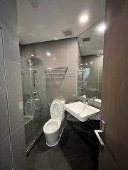 Modern bathroom interior with glass shower and ceramic fixtures