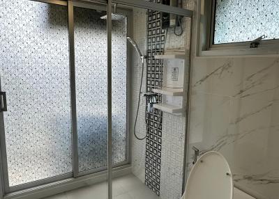 Modern bathroom with glass shower and marble tiles