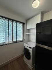 Compact space with washing machine, window blinds, and black appliances