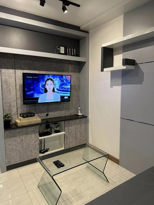 Modern living room with wall-mounted TV and glass coffee table