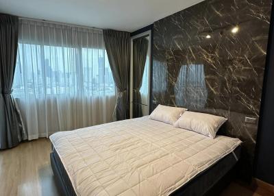 Modern bedroom with large bed and dark accent wall