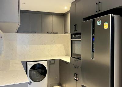 Modern kitchen with stainless steel appliances and built-in washing machine