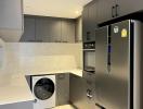 Modern kitchen with stainless steel appliances and built-in washing machine