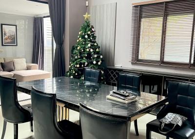 Spacious dining room with a large table and Christmas tree decoration