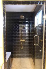 Modern bathroom with black subway tiles and glass shower enclosure