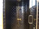Modern bathroom with black subway tiles and glass shower enclosure