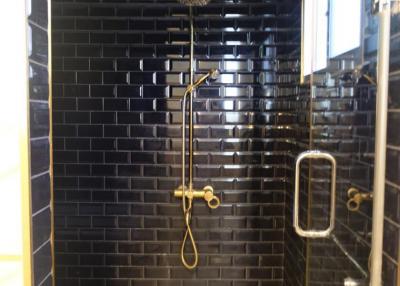Modern bathroom with black subway tiles and glass shower enclosure