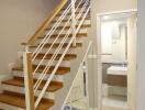 Modern staircase with wooden steps and white balustrade leading to an upper level