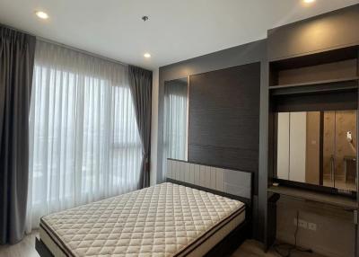 Spacious bedroom with large bed, wooden flooring, and ample natural light