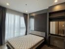 Spacious bedroom with large bed, wooden flooring, and ample natural light