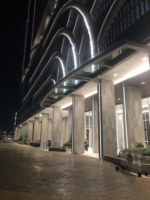 Modern high-rise building exterior at night with illuminated facade