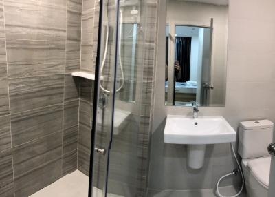 Modern bathroom interior with glass shower, sink, and toilet