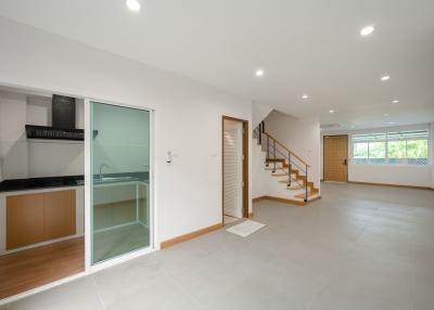 Bright and spacious open plan living area with staircase and kitchenette