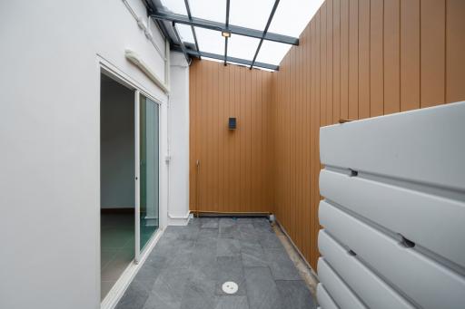 Compact patio area with glass roof and wooden walls