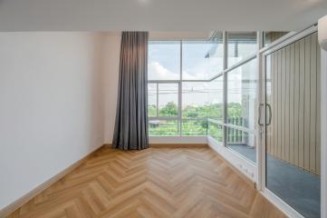 Bright and airy bedroom with herringbone wooden floor and large windows