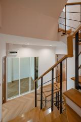 Modern staircase with wooden steps and metal balusters leading to the upper floor, showcasing the interior design and spaciousness