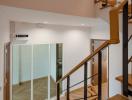 Modern staircase with wooden steps and metal balusters leading to the upper floor, showcasing the interior design and spaciousness