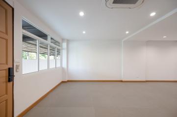 Spacious empty room with large windows and recessed lighting