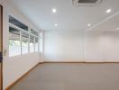 Spacious empty room with large windows and recessed lighting