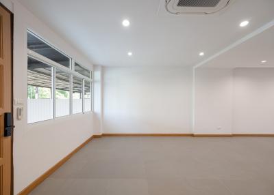 Spacious empty room with large windows and recessed lighting