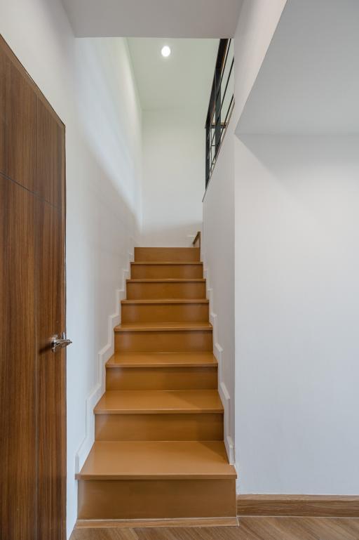 Elegant wooden staircase with white walls in a modern home