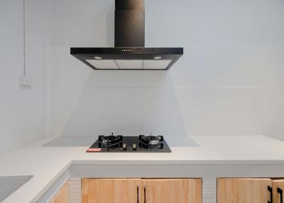 Modern kitchen with stainless steel extractor hood and gas cooktop