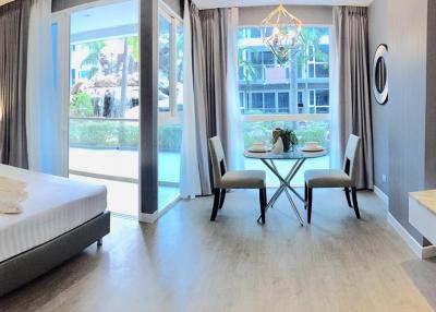 Modern bedroom with sitting area and poolside view through large windows