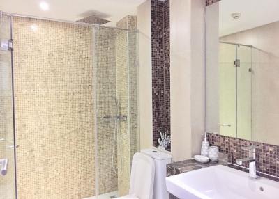 Modern bathroom with mosaic tiles and glass shower enclosure