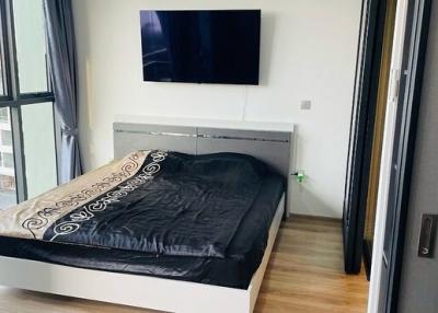 Modern bedroom with a mounted television and city view