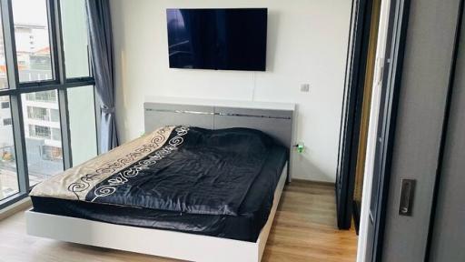 Modern bedroom with a mounted television and city view