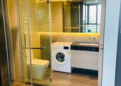 Modern bathroom with glass shower enclosure and laundry facilities