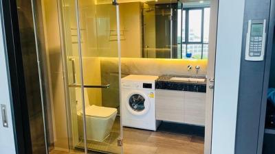 Modern bathroom with glass shower enclosure and laundry facilities