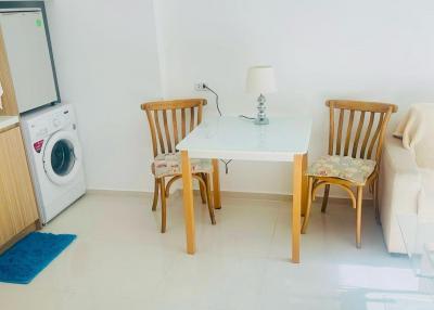 Compact kitchen space with dining table, chairs and home appliances