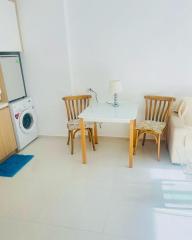 Compact kitchen space with dining table, chairs and home appliances