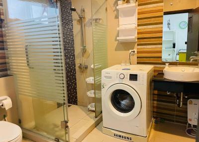 Modern bathroom with glass shower stall and washing machine