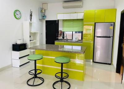 Modern kitchen with green cabinets and breakfast bar