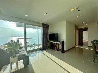 Bright and spacious living room with ocean view and balcony access