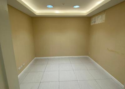 Empty room with tiled floor and recessed lighting