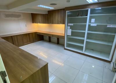 Spacious empty kitchen with wooden cabinetry and tile flooring