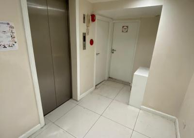 Elevator lobby with white tiled flooring in an apartment building
