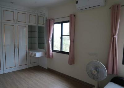 Cozy bedroom with built-in wardrobe and air conditioning unit