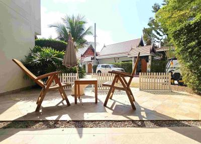Sunny outdoor patio area with wooden furniture
